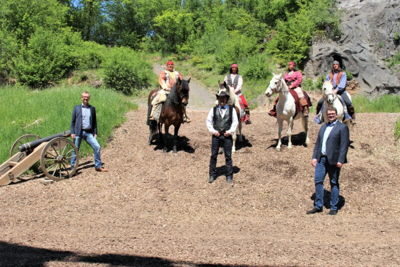 Elspe Festival-Geschäftsführer Philipp Aßhoff und Bürgermeister Tobias Puspas sehen gemeinsam mit Vierbeiner Hektor der neuen Saison entgegen. (Foto: KARL MAY & Co./Kunz)