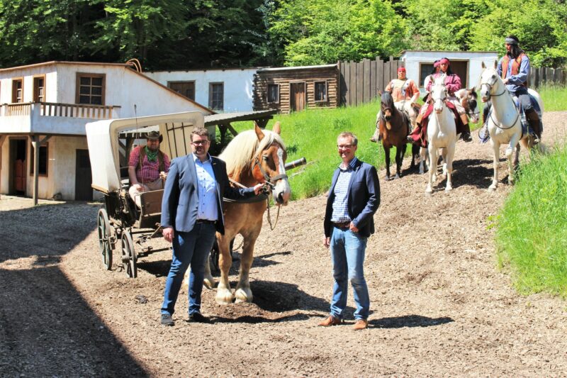 Elspe Festival-Geschäftsführer Philipp Aßhoff und Bürgermeister Tobias Puspas sehen gemeinsam mit Vierbeiner Hektor der neuen Saison entgegen. (Foto: KARL MAY & Co./Kunz)